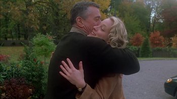 Movie still from “Meet the Parents” (2000), directed by Jay Roach – A man and a woman hugging each other in a park; Medium shot, Low angle