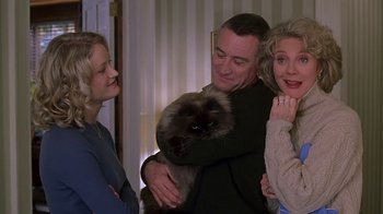 Movie still from “Meet the Parents” (2000), directed by Jay Roach – Two women and a man holding a cat in their arms; Medium shot, Low angle