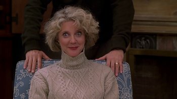 Movie still from “Meet the Parents” (2000), directed by Jay Roach – A woman in a sweater sitting on a chair; Close Up shot, Over the shoulder angle