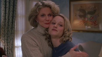 Movie still from “Meet the Parents” (2000), directed by Jay Roach – A woman and a woman hugging each other in front of a mirror; Close Up shot, High angle