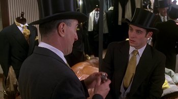 Movie still from “Meet the Parents” (2000), directed by Jay Roach – A man in a top hat and a man in a suit; Medium shot, Over the shoulder angle