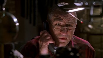 Movie still from “Meet the Parents” (2000), directed by Jay Roach – An older man talking on a phone in a dark room; Close Up shot, Low angle