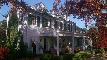 Movie still from “Meet the Parents” (2000), directed by Jay Roach – A person standing in front of a large white house; Extreme Wide shot, Low angle