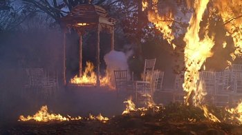 Movie still from “Meet the Parents” (2000), directed by Jay Roach – A gazebo is set on fire with chairs around it; Extreme Wide shot, High angle