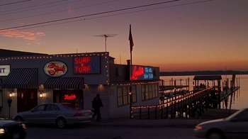 Movie still from “Meet the Parents” (2000), directed by Jay Roach – A person walking down a street near a pier; Extreme Wide shot, Low angle