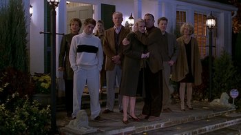 Movie still from “Meet the Parents” (2000), directed by Jay Roach – A group of people standing in front of a house; Wide shot, Low angle