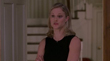 Movie still from “Meet the Parents” (2000), directed by Jay Roach – A woman in a black dress standing in front of a staircase; Close Up shot, Low angle