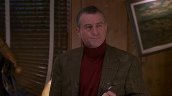 Movie still from “Meet the Parents” (2000), directed by Jay Roach – A person wearing a suit and holding a pen; Close Up shot, Over the shoulder angle