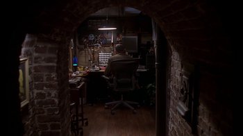 Movie still from “Meet the Parents” (2000), directed by Jay Roach – A man sitting at a computer desk in front of a computer; Wide shot, High angle