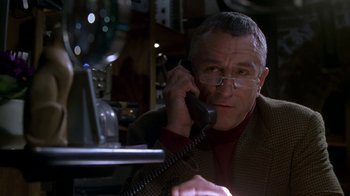 Movie still from “Meet the Parents” (2000), directed by Jay Roach – An older man talking on a phone while sitting at a desk; Close Up shot, Low angle