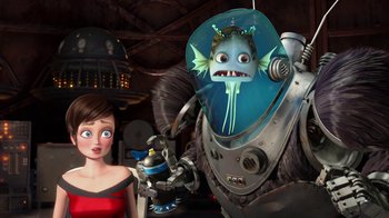 Movie still from “Megamind” (2010), directed by Tom McGrath – A woman standing next to an animated creature; Medium shot, Over the shoulder angle
