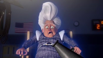 Movie still from “Megamind” (2010), directed by Tom McGrath – An old woman with white hair is holding an object; Medium shot, Low angle