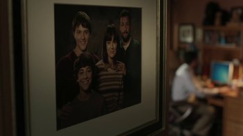 Movie still from “Men, Women & Children” (2014), directed by Jason Reitman – A picture of a group of people hanging on a wall; Medium shot, Over the shoulder angle