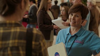 Movie still from “Men, Women & Children” (2014), directed by Jason Reitman – A group of people standing in a room with papers; Medium shot, Over the shoulder angle