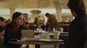 Movie still from “Men, Women & Children” (2014), directed by Jason Reitman – A woman sitting at a table reading a book; Medium shot, Over the shoulder angle
