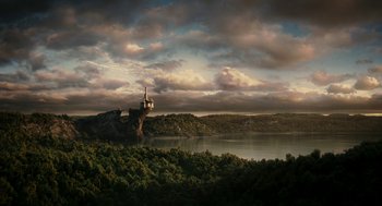 Movie still from “Mirror Mirror” (2012), directed by Tarsem Singh – A castle on top of a hill near a body of water; Extreme Wide shot, High angle