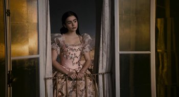 Movie still from “Mirror Mirror” (2012), directed by Tarsem Singh – A woman in a dress is looking out of a window; Medium shot, Low angle