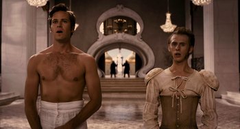Movie still from “Mirror Mirror” (2012), directed by Tarsem Singh – Two men standing next to each other in front of an archway; Medium shot, Low angle