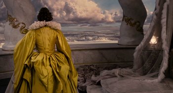 Movie still from “Mirror Mirror” (2012), directed by Tarsem Singh – A woman in a yellow dress looking out at a cloudy sky; Wide shot, Low angle