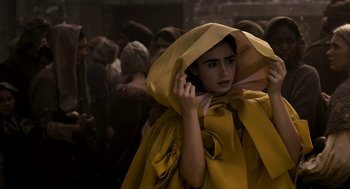 Movie still from “Mirror Mirror” (2012), directed by Tarsem Singh – A woman in a yellow cape talking on a cell phone; Medium shot, High angle