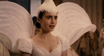 Movie still from “Mirror Mirror” (2012), directed by Tarsem Singh – A woman in a white dress with wings on her head; Close Up shot, Over the shoulder angle