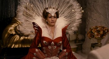 Movie still from “Mirror Mirror” (2012), directed by Tarsem Singh – A woman wearing a red dress and a white feather headdress; Close Up shot, Low angle