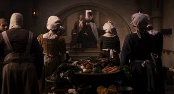 Movie still from “Mirror Mirror” (2012), directed by Tarsem Singh – A group of people standing in front of a bowl of vegetables; Wide shot, High angle