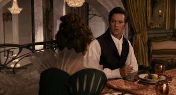 Movie still from “Mirror Mirror” (2012), directed by Tarsem Singh – A man and a woman sitting at a dinner table; Medium shot, Over the shoulder angle