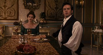 Movie still from “Mirror Mirror” (2012), directed by Tarsem Singh – A man and a woman sitting at a dinner table; Medium shot, Over the shoulder angle