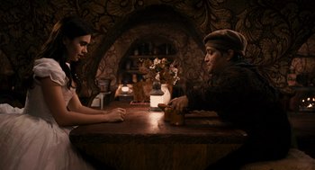 Movie still from “Mirror Mirror” (2012), directed by Tarsem Singh – A man and a woman sitting at a table with a cat; Medium shot, Over the shoulder angle