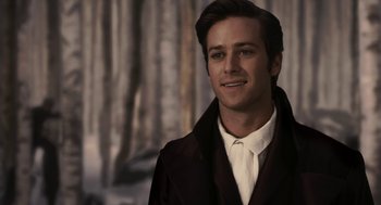 Movie still from “Mirror Mirror” (2012), directed by Tarsem Singh – A man in a suit and tie standing in front of trees; Close Up shot, Over the shoulder angle