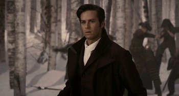 Movie still from “Mirror Mirror” (2012), directed by Tarsem Singh – A man in a brown coat standing in front of trees; Medium shot, Over the shoulder angle