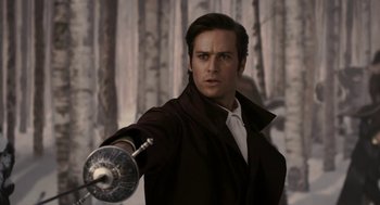 Movie still from “Mirror Mirror” (2012), directed by Tarsem Singh – A man in a brown jacket holding a sword; Close Up shot, Over the shoulder angle