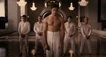 Movie still from “Mirror Mirror” (2012), directed by Tarsem Singh – A group of men standing around a man in a towel; Wide shot, Low angle