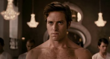 Movie still from “Mirror Mirror” (2012), directed by Tarsem Singh – A man with no shirt is looking at the camera; Close Up shot, Over the shoulder angle