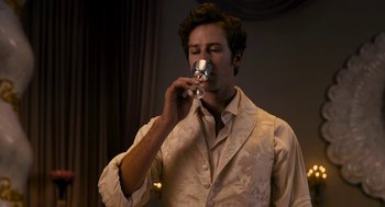 Movie still from “Mirror Mirror” (2012), directed by Tarsem Singh – A man in a white shirt is drinking a glass of wine; Close Up shot, Low angle
