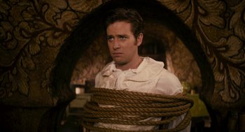 Movie still from “Mirror Mirror” (2012), directed by Tarsem Singh – A man in white shirt and rope around his neck; Medium shot, High angle