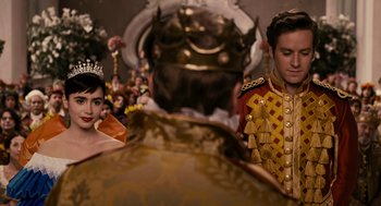 Movie still from “Mirror Mirror” (2012), directed by Tarsem Singh – A man and a woman dressed up in costume; Medium shot, Over the shoulder angle