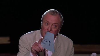 Movie still from “Miss Congeniality” (2000), directed by Donald Petrie – An older man holding a piece of paper in front of his face; Medium shot, Low angle