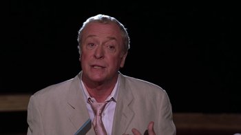 Movie still from “Miss Congeniality” (2000), directed by Donald Petrie – An older man wearing a beige suit and a pink tie; Close Up shot, High angle