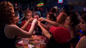 Movie still from “Miss Congeniality” (2000), directed by Donald Petrie – A group of people sitting at a table holding hands; Medium shot, High angle