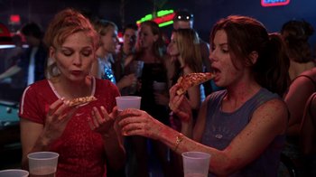 Movie still from “Miss Congeniality” (2000), directed by Donald Petrie – A group of women eating pizza at a party; Medium shot, High angle