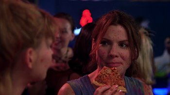 Movie still from “Miss Congeniality” (2000), directed by Donald Petrie – A woman holding a piece of pizza in her hand; Medium shot, Over the shoulder angle