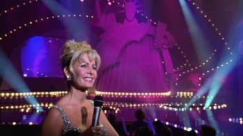 Movie still from “Miss Congeniality” (2000), directed by Donald Petrie – A woman holding a microphone in front of a statue of liberty; Medium shot, Low angle