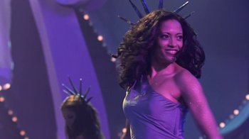 Movie still from “Miss Congeniality” (2000), directed by Donald Petrie – A woman in a purple dress with a crown of stars on her head; Medium shot, Low angle