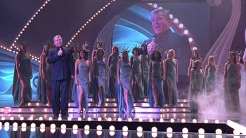 Movie still from “Miss Congeniality” (2000), directed by Donald Petrie – A group of people standing in front of a screen; Wide shot, Low angle