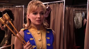 Movie still from “Miss Congeniality” (2000), directed by Donald Petrie – A woman in a blue and yellow uniform holding a pair of chopsticks; Close Up shot, Over the shoulder angle