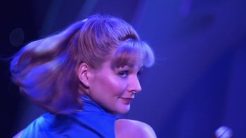 Movie still from “Miss Congeniality” (2000), directed by Donald Petrie – A woman in a blue shirt is looking at the camera; Close Up shot, Low angle