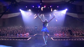 Movie still from “Miss Congeniality” (2000), directed by Donald Petrie – A woman in a blue dress is performing a show; Wide shot, High angle