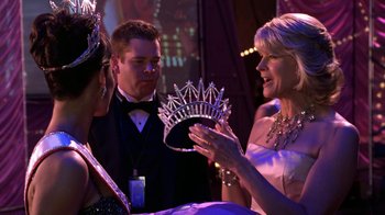 Movie still from “Miss Congeniality” (2000), directed by Donald Petrie – A woman wearing a tiara talking to two other people; Close Up shot, Over the shoulder angle